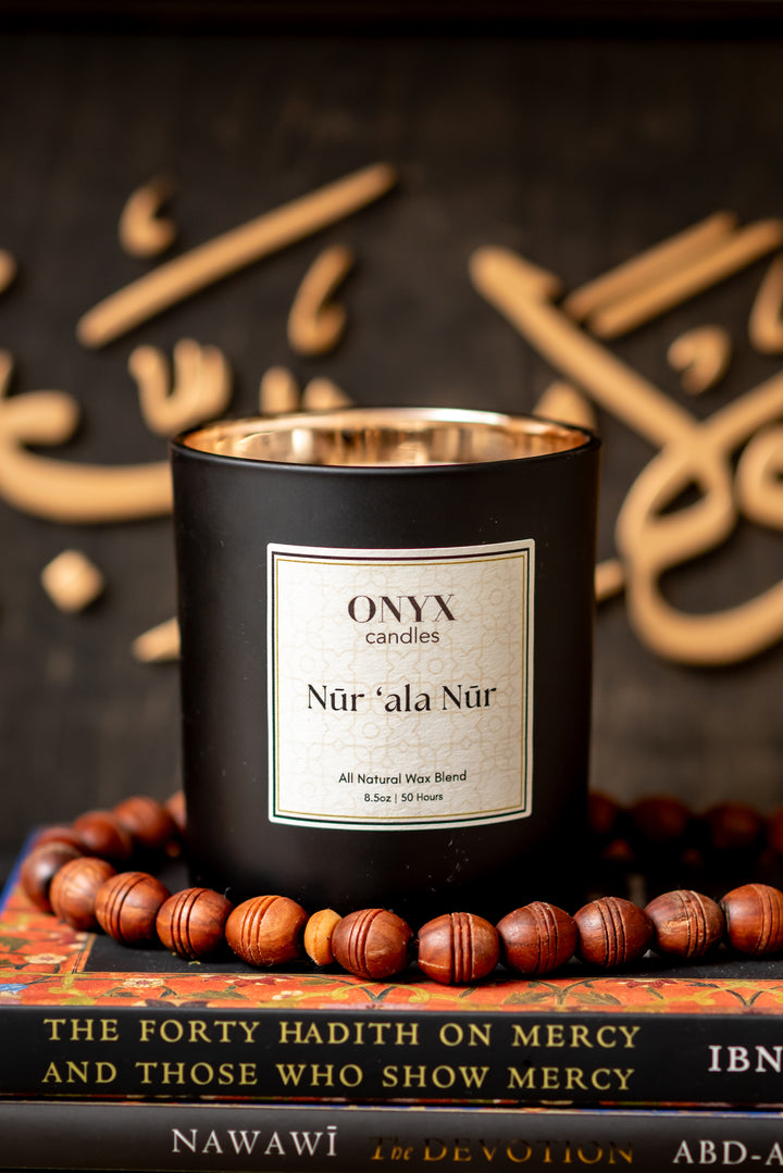 Nūr ‘ala Nūr candle with prayer beads and Islamic calligraphy